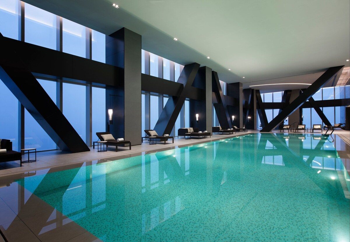 High-altitude indoor lap pool at Niccolo Chongqing with city windows