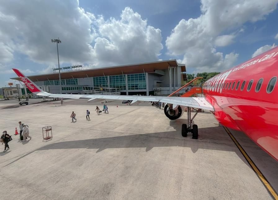 Passengers boarding an AirAsia aircraft by the wing at a regional terminal