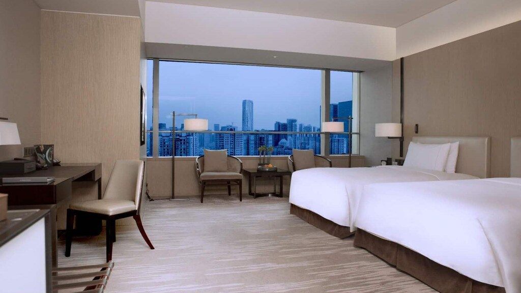 Niccolo guest room with twin beds and a blue-hour city view